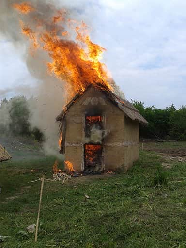Photograph of a replica house from Nebelivka on fire